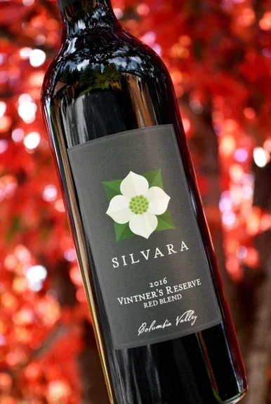 A bottle of Silvara 2016 Vintner's Reserve Red Blend wine from Columbia Valley against a backdrop of red autumn or fall foliage.