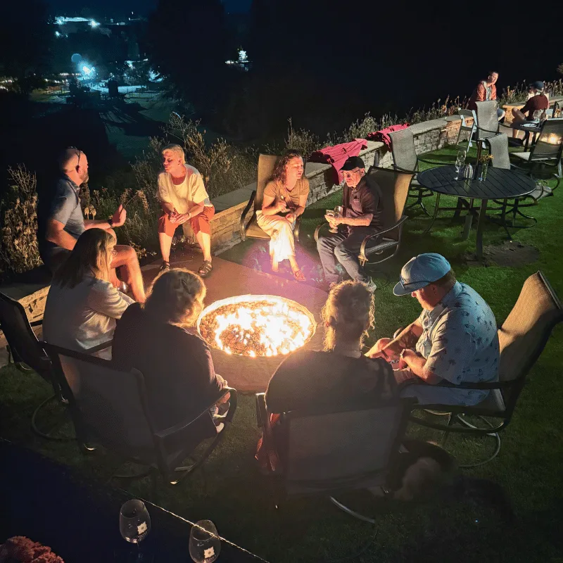 Friends sharing wine outdoors among the trees