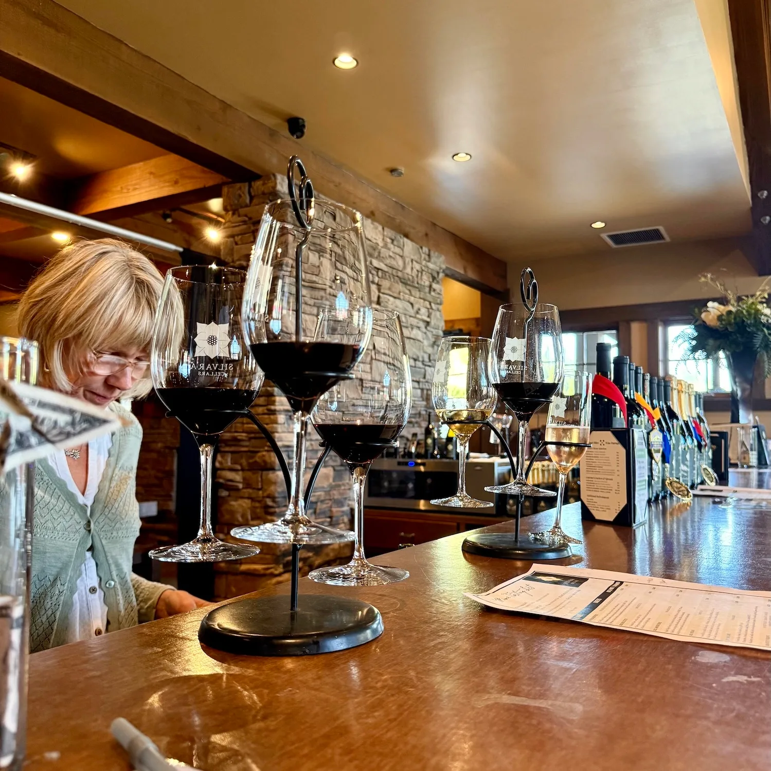 A flight of wine glasses on a wooden tasting counter
