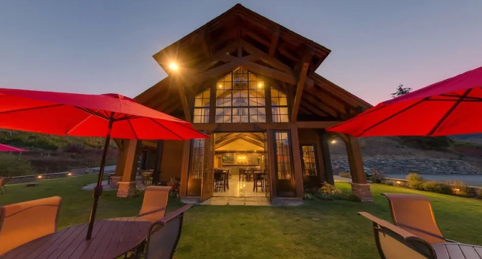 Outdoor patio tables with umbrellas lit up in the evening at Silvara Cellars, a corporate event venue in Leavenworth