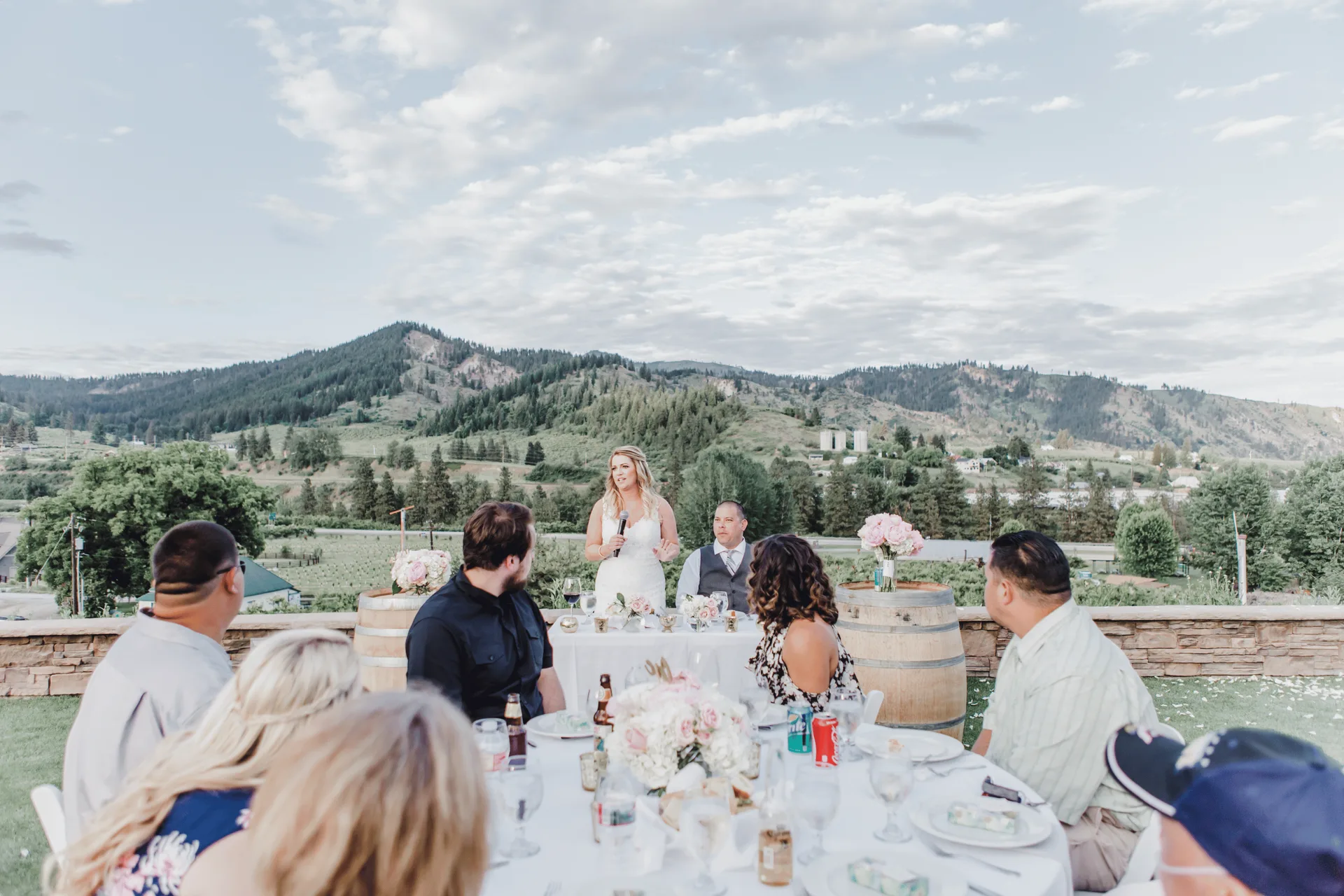 Bride giving a speech to seated guests on the hillside at Silvara Cellars, overlooking the Cascade foothills